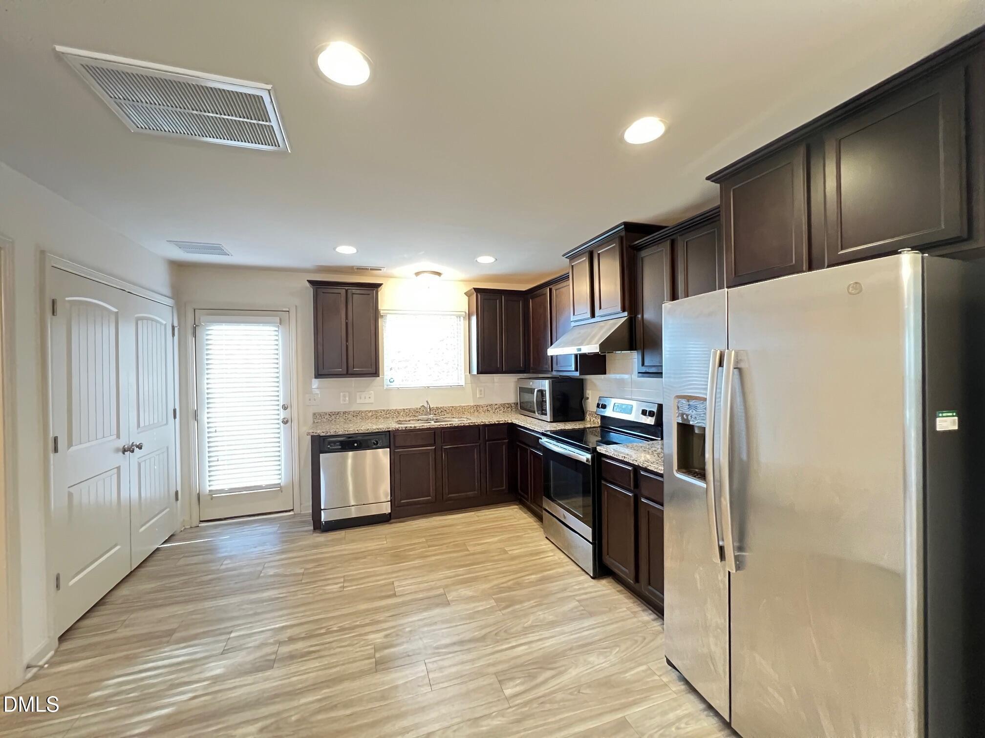 18 Rochambeau Court Durham, NC 27704 - Photo 3 of 12 a kitchen with granite countertop a refrigerator and a stove top oven