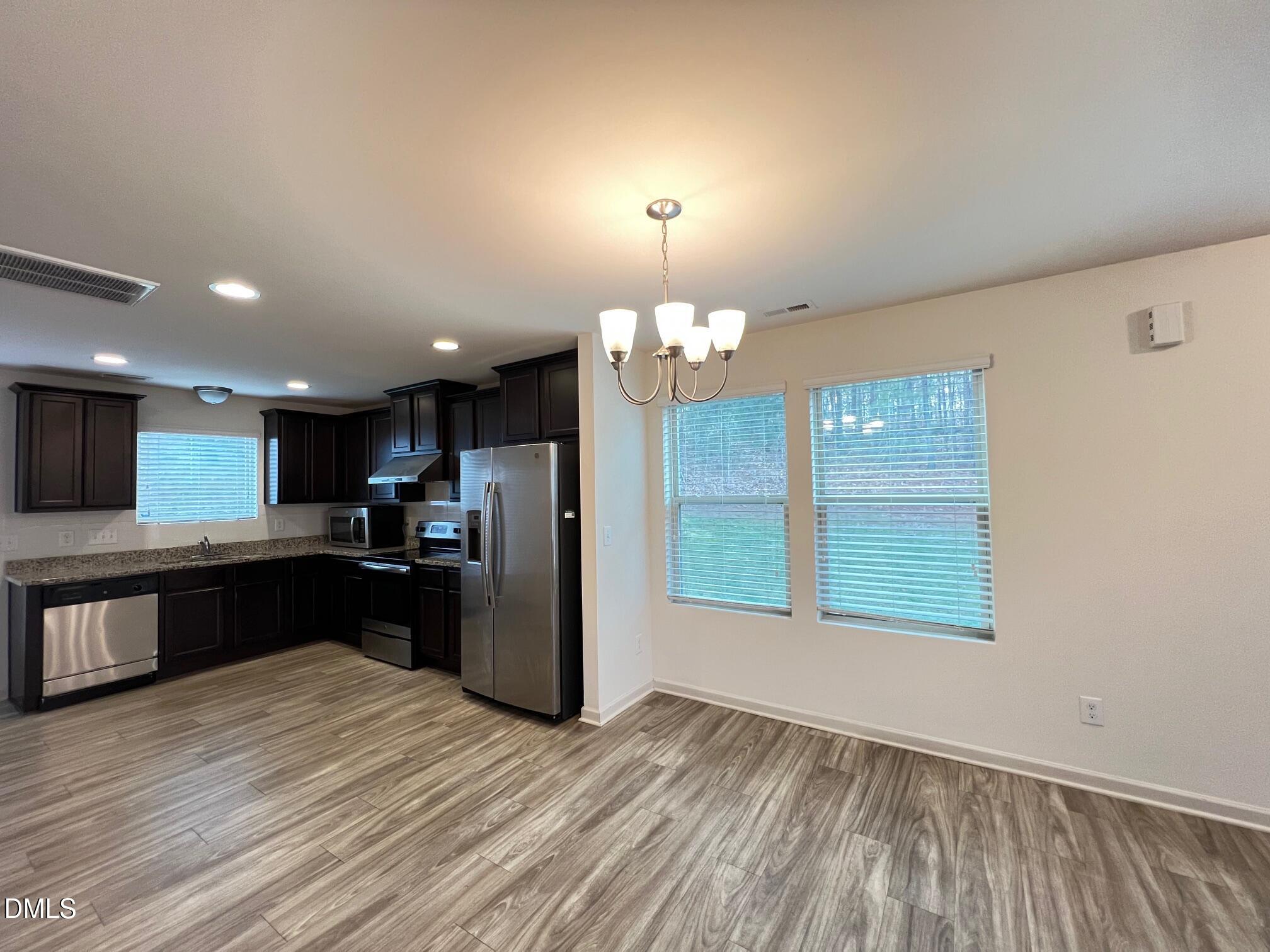 18 Rochambeau Court Durham, NC 27704 - Photo 4 of 12 a kitchen with stainless steel appliances kitchen island wooden cabinets and granite counter tops