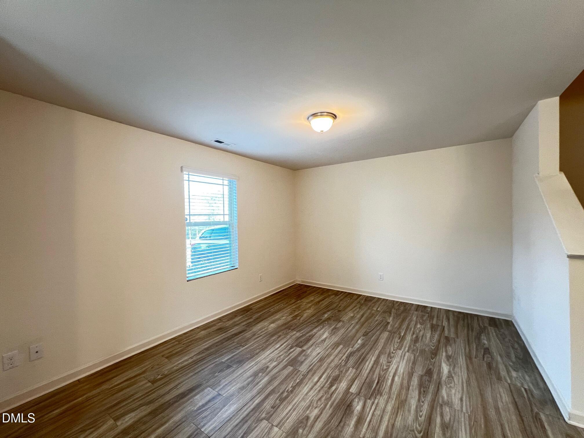 18 Rochambeau Court Durham, NC 27704 - Photo 5 of 12 an empty room with wooden floor and windows