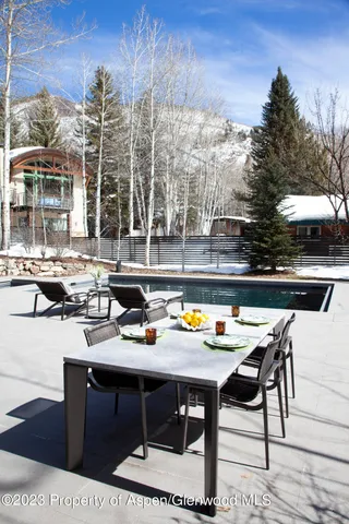 a view of a patio with table and chairs potted plants and large tree
