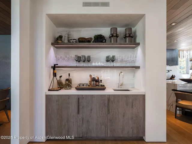 a living room with furniture kitchen view and a large window