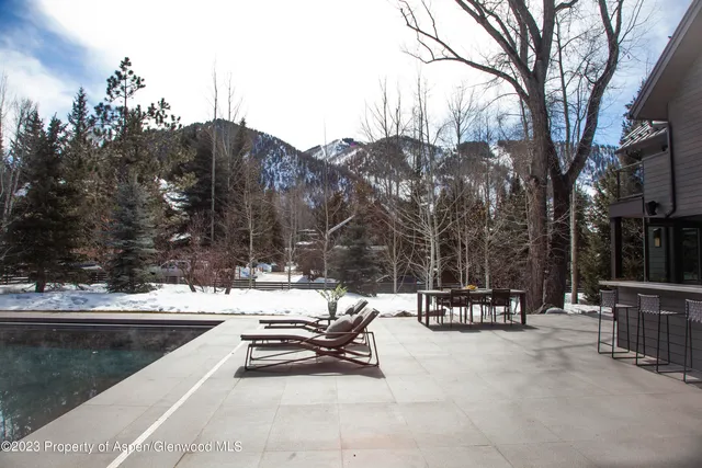 a view of a patio with table and chairs potted plants and a large tree
