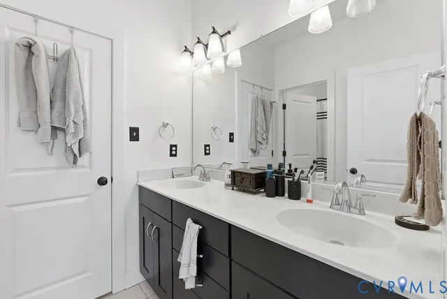 a bathroom with double vanity sinks a vanity and a mirror