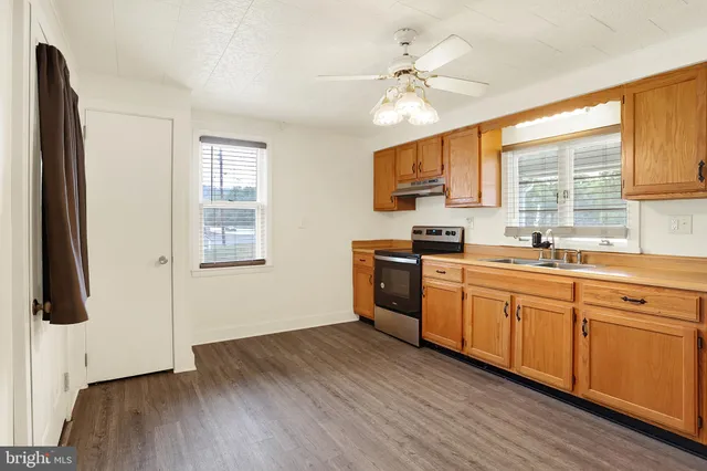 a kitchen with stainless steel appliances a sink cabinets and wooden floor