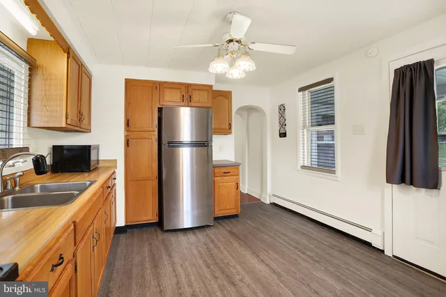 a kitchen with a refrigerator a sink and dishwasher with wooden floor