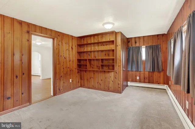 a view of an empty room with cabinet and a window