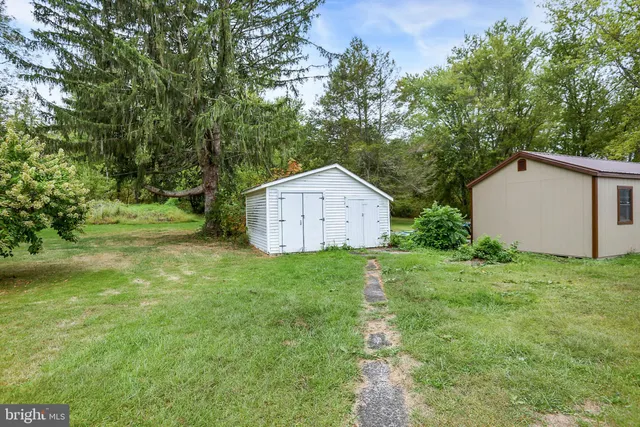 a house is sitting in middle od the grass