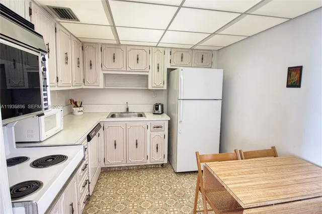 a kitchen with white cabinets and white appliances