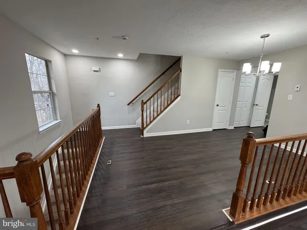 a view of staircase with railing and a chandelier