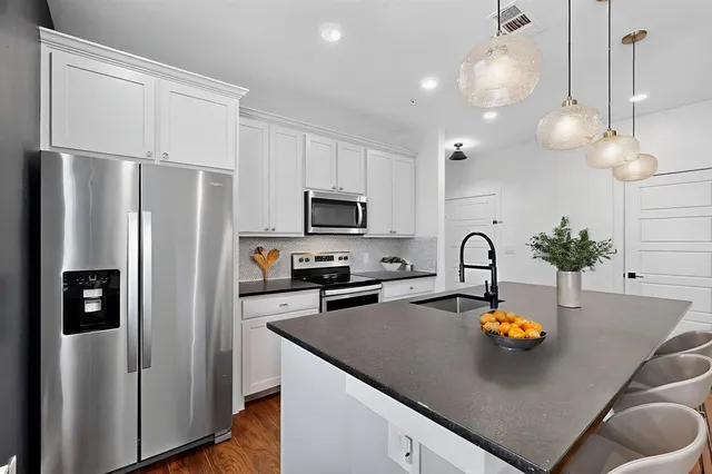 a kitchen with stainless steel appliances a refrigerator sink and stove