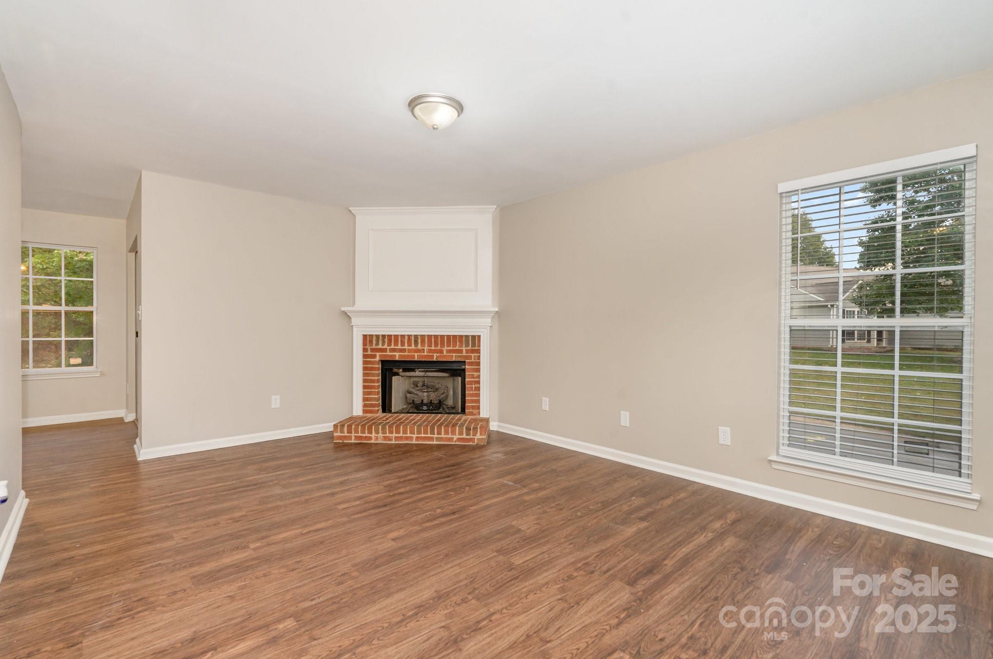 7527 Henderson Park Road Huntersville, NC 28078 - Photo 12 of 18 an empty room with wooden floor fireplace and windows