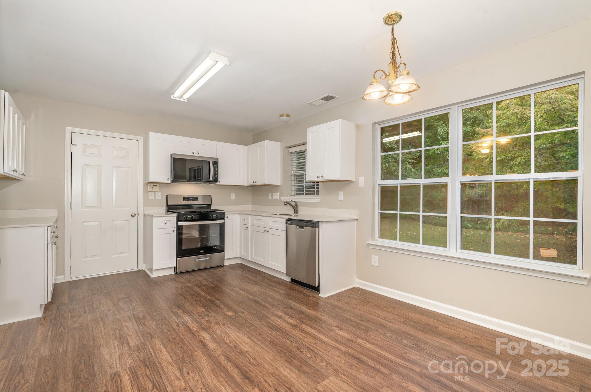 7527 Henderson Park Road Huntersville, NC 28078 - Photo 3 of 18 a kitchen with a refrigerator and white cabinets
