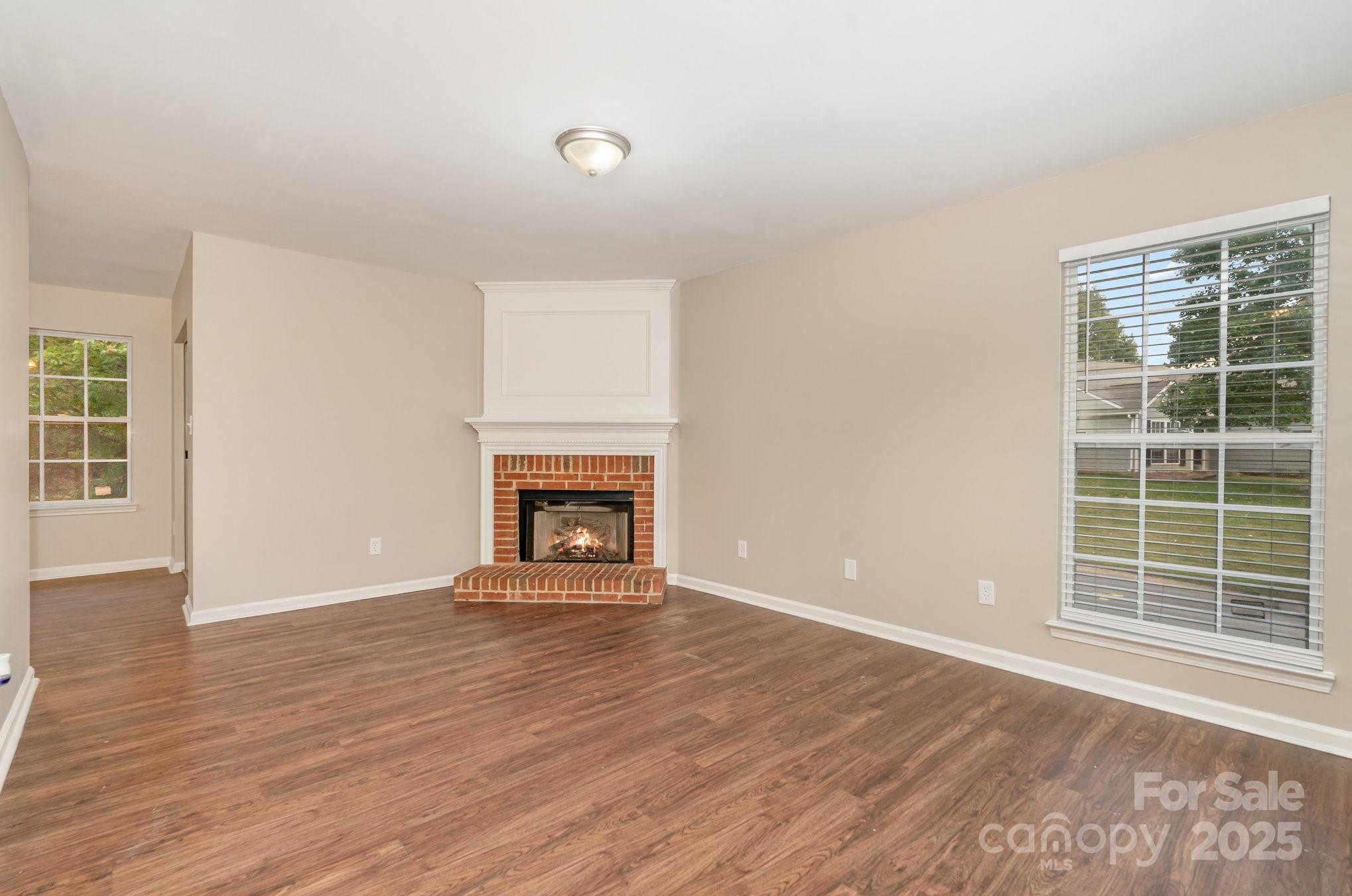 7527 Henderson Park Road Huntersville, NC 28078 - Photo 7 of 18 an empty room with wooden floor fireplace and windows