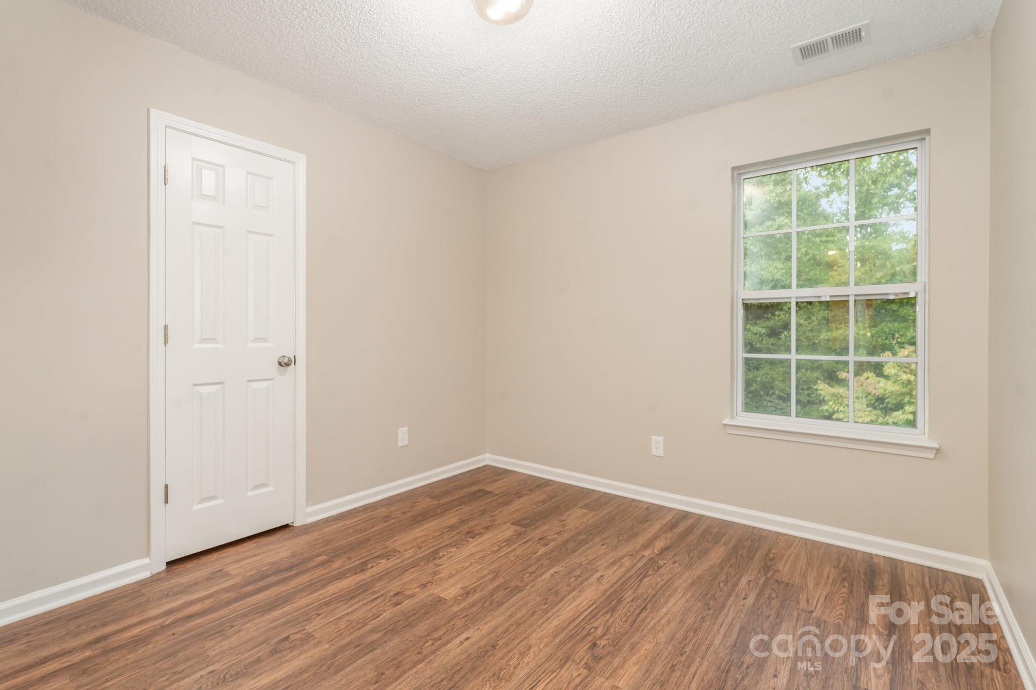 7527 Henderson Park Road Huntersville, NC 28078 - Photo 8 of 18 an empty room with wooden floor and windows
