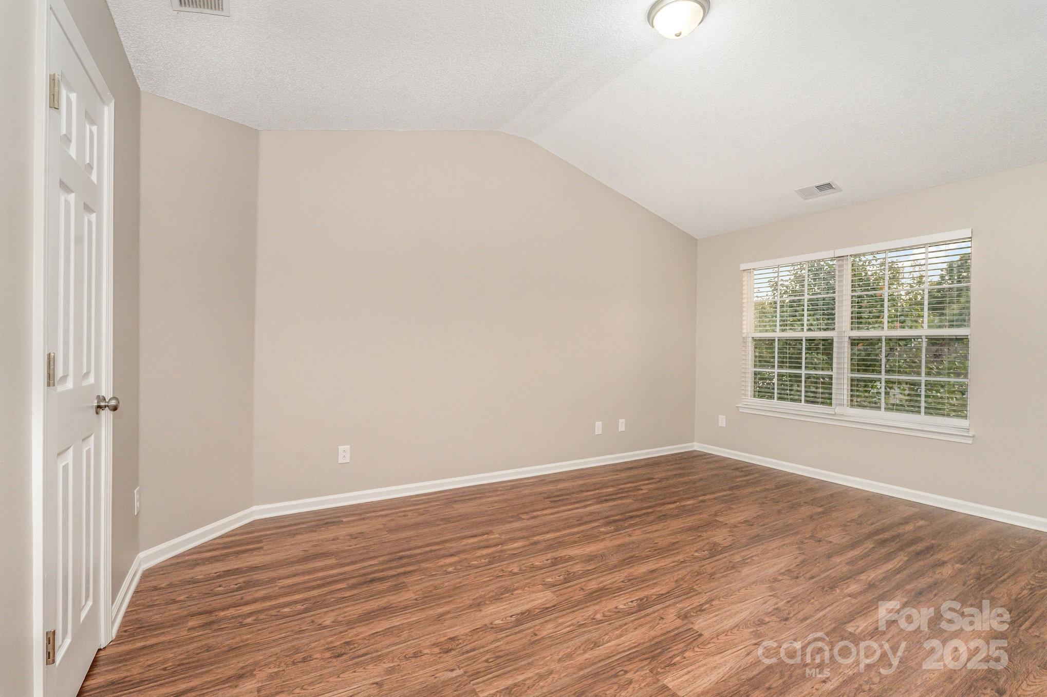 7527 Henderson Park Road Huntersville, NC 28078 - Photo 9 of 18 a view of an empty room with wooden floor and a window
