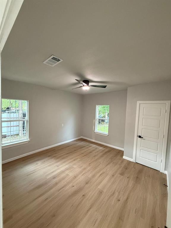 758 Bethpage Avenue Dallas, TX 75217 - Photo 16 of 20 an empty room with wooden floor and windows