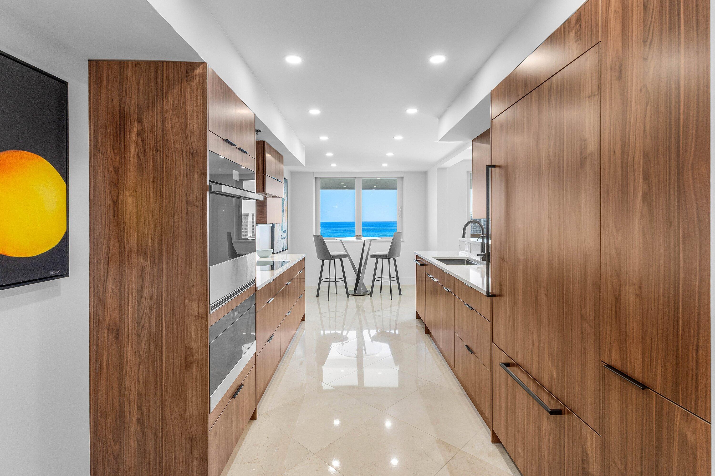 901 East Camino Real, Unit 15D Boca Raton, FL 33432 - Photo 12 of 42 a view of a kitchen with kitchen island a lot of counter top space a sink and windows