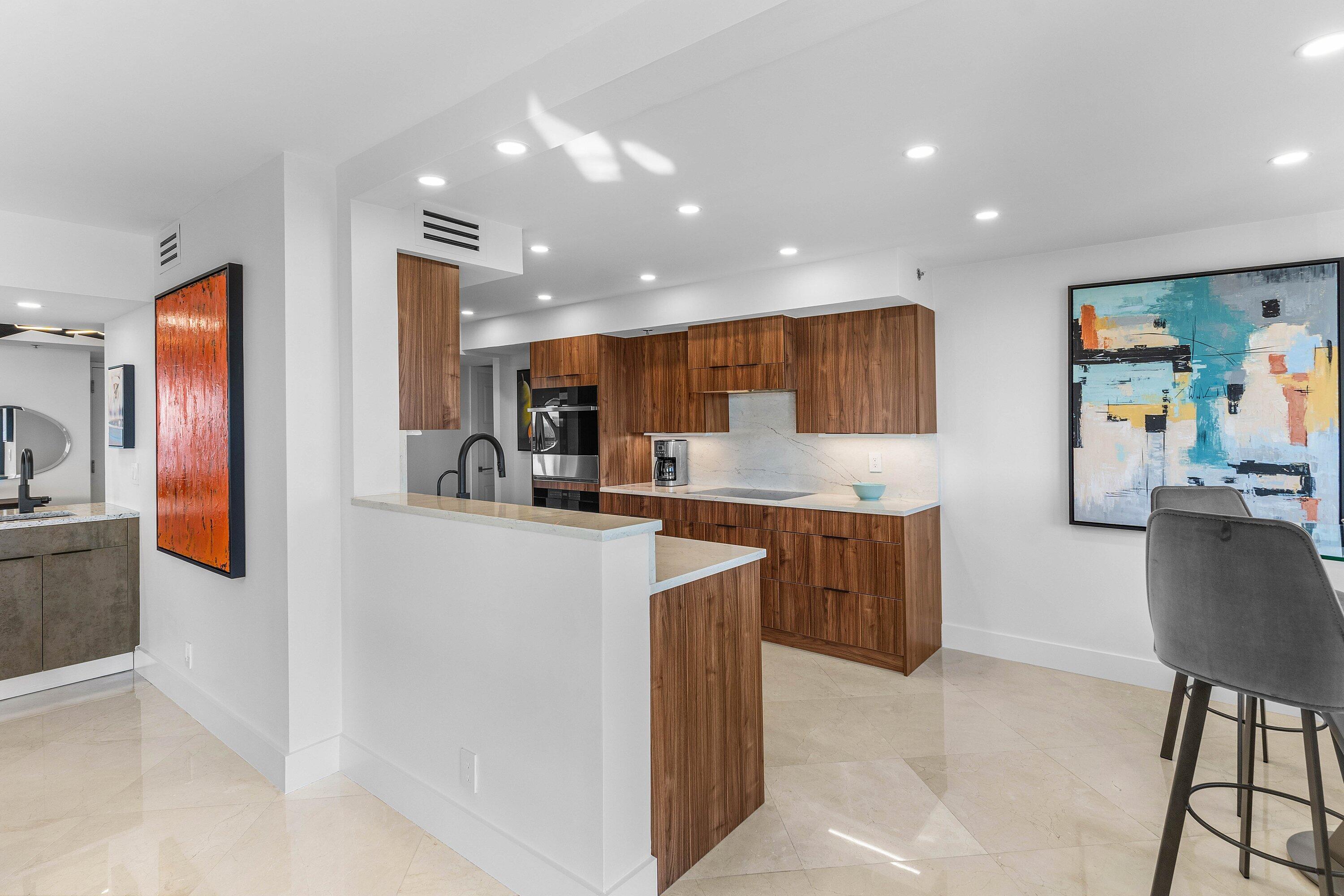 901 East Camino Real, Unit 15D Boca Raton, FL 33432 - Photo 17 of 42 a kitchen view with stainless steel appliances kitchen island granite countertop a refrigerator and a stove top oven