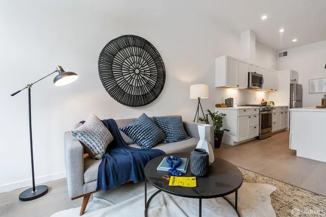 a living room with furniture a rug and kitchen view