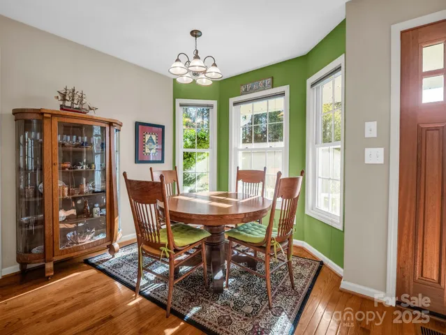 a view of a dining room with furniture a chandelier and wooden floor