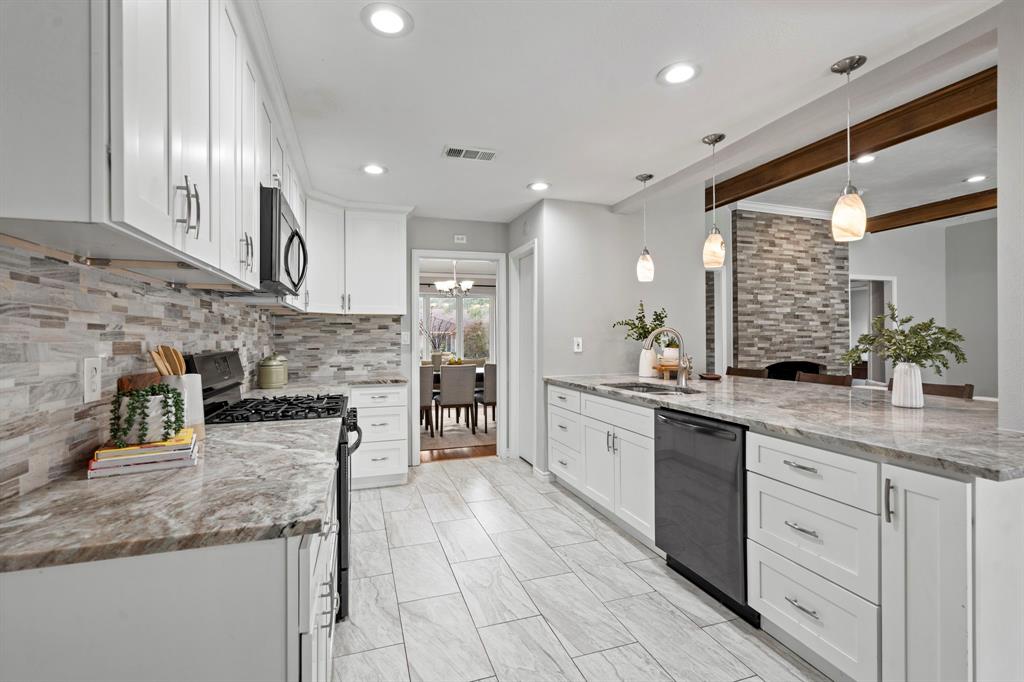 6349 Highgate Lane Dallas, TX 75214 - Photo 17 of 38 a large kitchen with stainless steel appliances kitchen island granite countertop a sink and cabinets