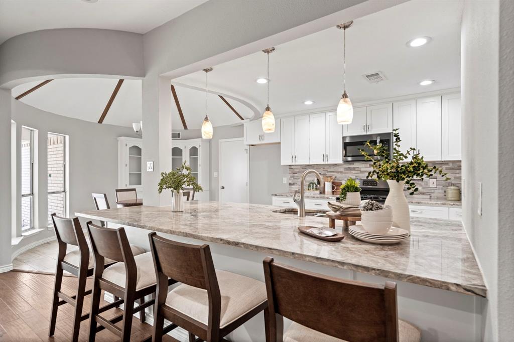 6349 Highgate Lane Dallas, TX 75214 - Photo 10 of 38 a kitchen with kitchen island granite countertop a table and chairs in it