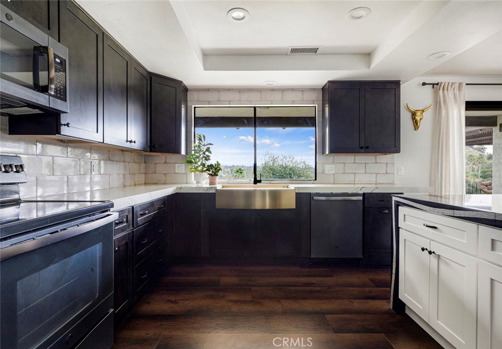 2527 Olive Hill Lane Fallbrook, CA 92028 - Photo 17 of 65 a kitchen with stainless steel appliances wooden cabinets a stove and a sink