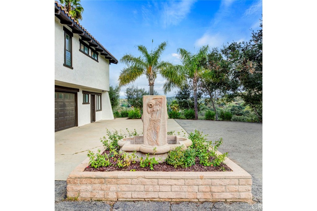 2527 Olive Hill Lane Fallbrook, CA 92028 - Photo 54 of 65 a front view of a house with a yard and fountain
