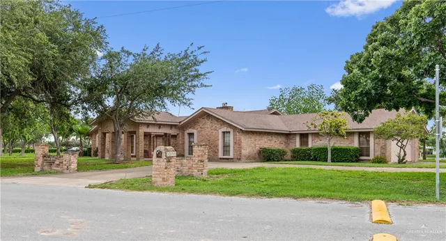 a front view of a house with a yard and trees