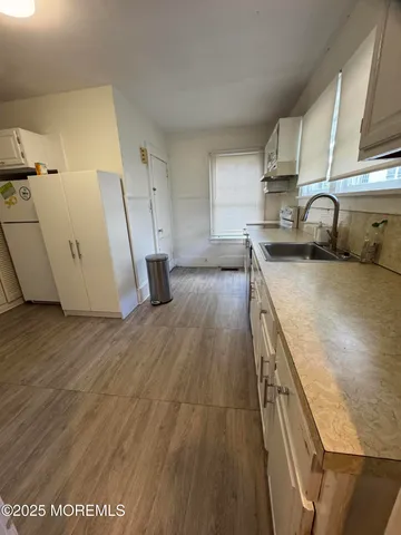 a kitchen with a sink a stove and cabinets