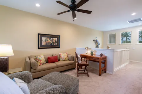 a living room with furniture and a ceiling fan