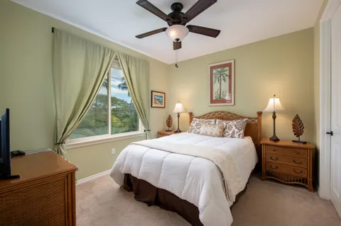 a bedroom with a bed and a flat tv screen on the dresser