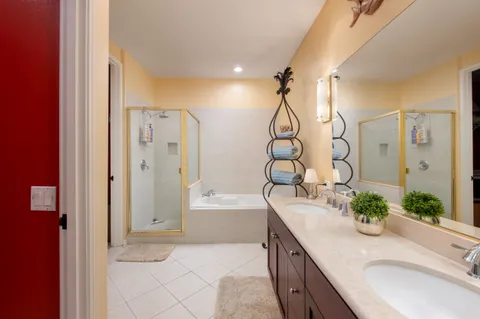 a bathroom with a granite countertop sink a mirror and a bathtub