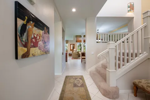 a view of staircase with furniture and lots of frames on wall
