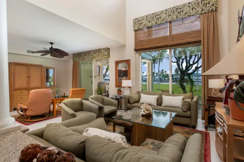 a living room with furniture two large windows and a fireplace