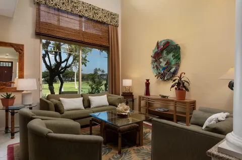a living room with furniture a floor to ceiling window and a flat screen tv