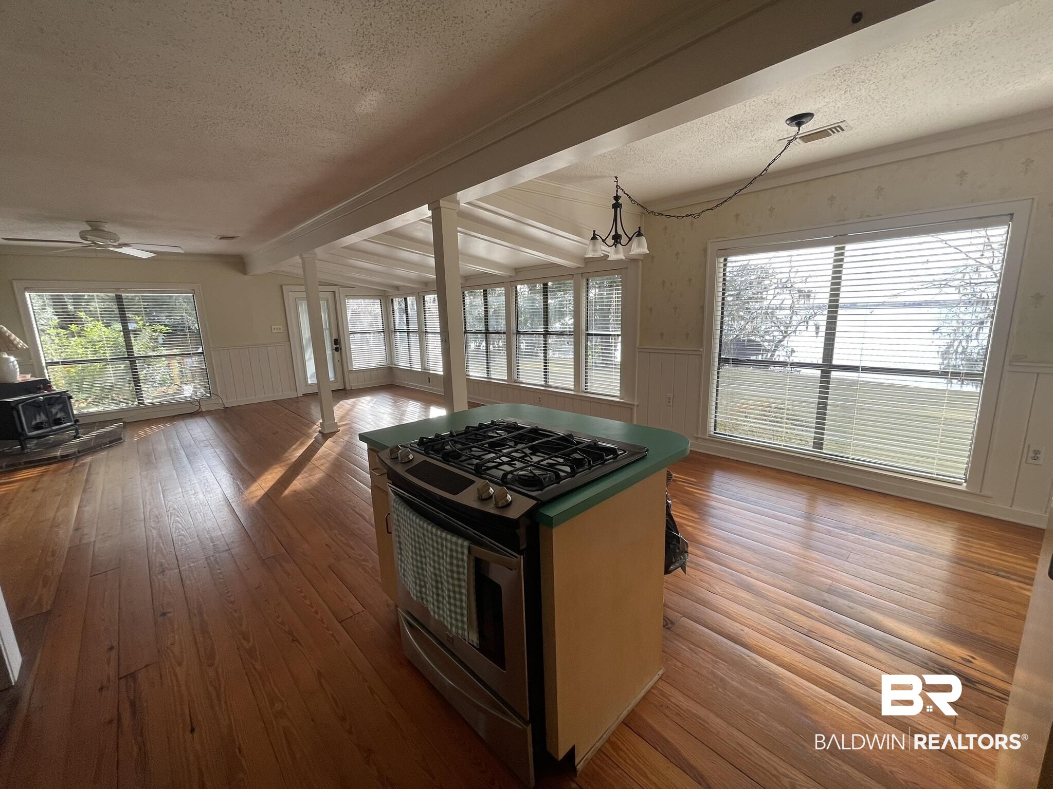 6621 Purvis Road Daphne, AL 36527 - Photo 58 of 59 Kitchen with wainscoting, stainless steel range with gas stovetop, a wood stove, open floor plan, and dark wood-style flooring