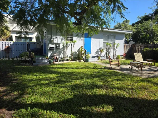 a view of a house with backyard and sitting area