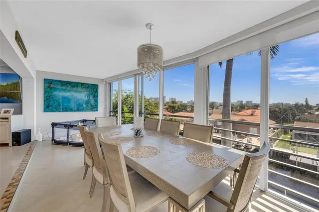 a dining room with furniture a chandelier and wooden floor