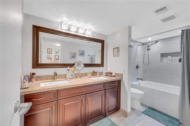 a spacious bedroom with a bed a couch and a chandelier