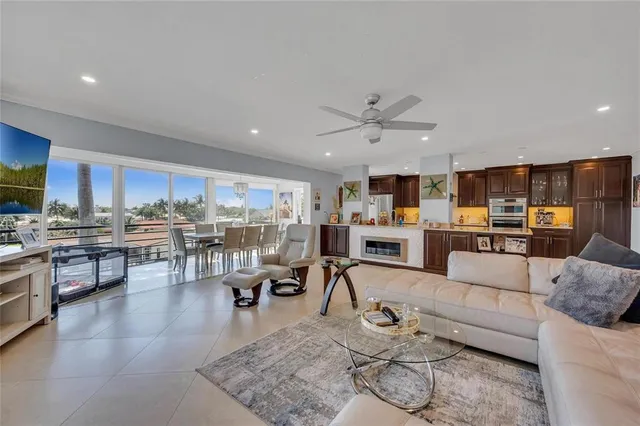 a living room with furniture kitchen view and a wooden floor