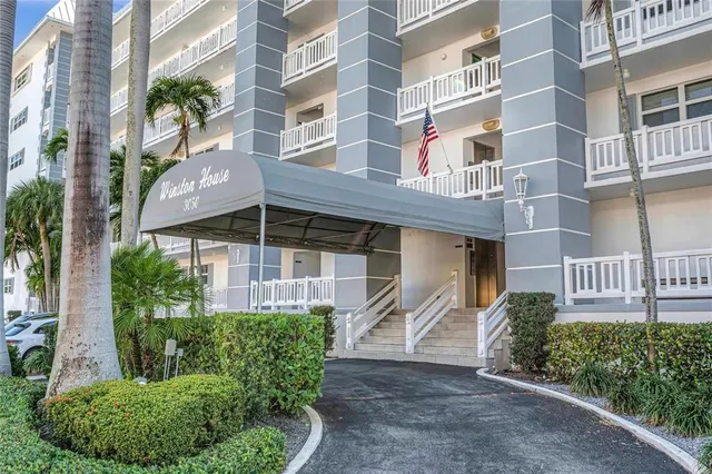 a living room with furniture a flat screen tv and a floor to ceiling window