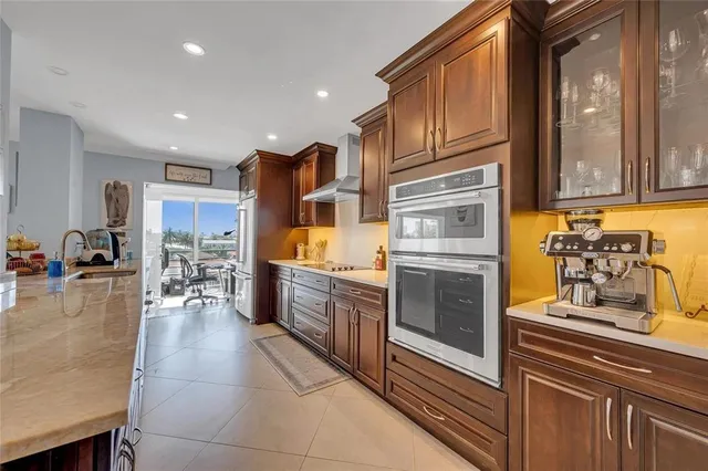 a kitchen with stainless steel appliances granite countertop a refrigerator and a stove top oven