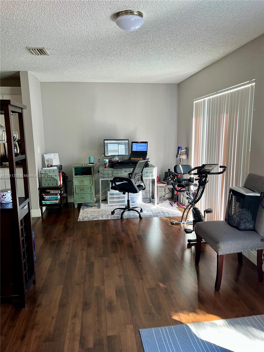 555 Racquet Club Road, Unit 25 Weston, FL 33326 - Photo 4 of 12 a living room with furniture and a wooden floor