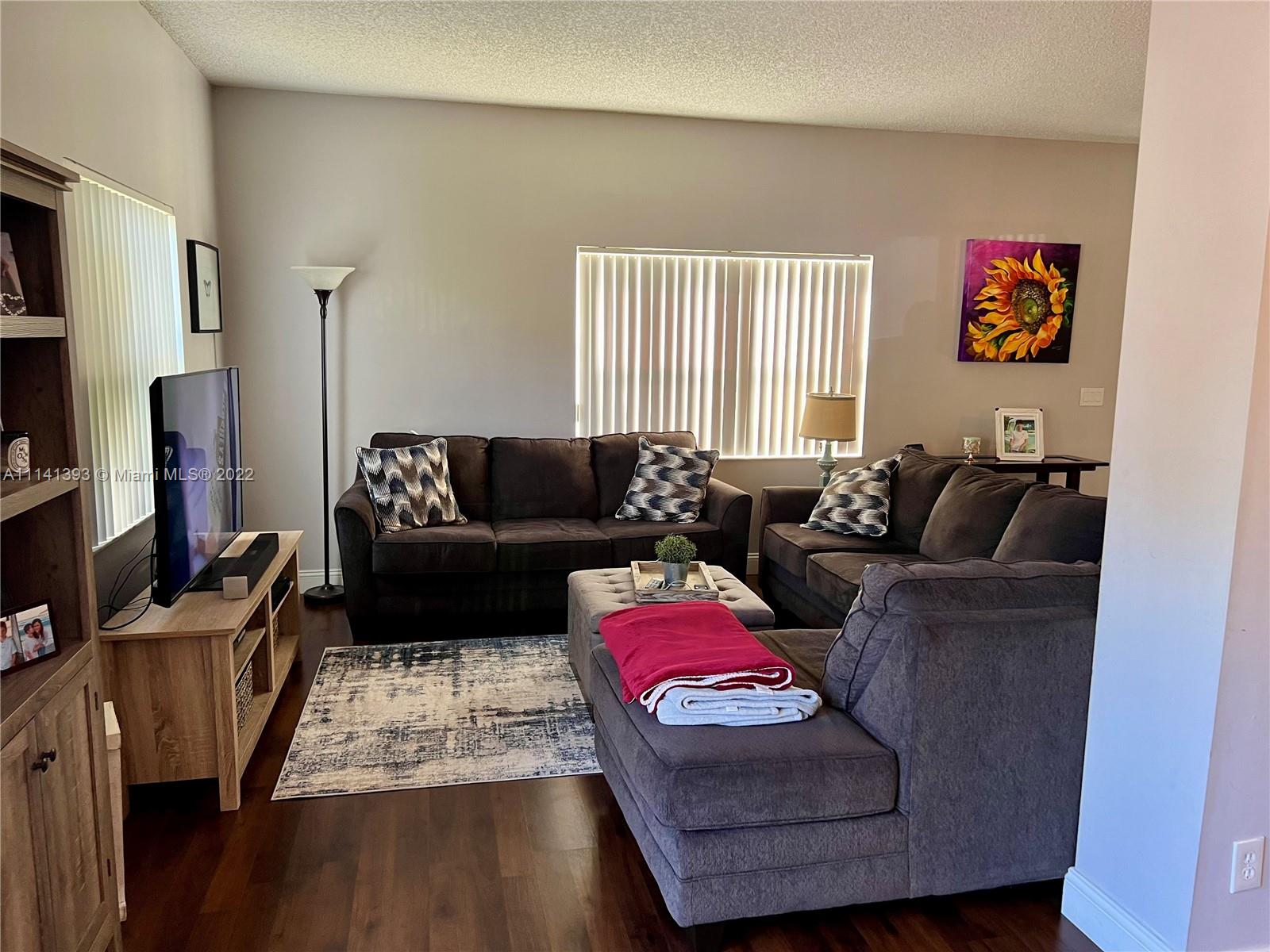 555 Racquet Club Road, Unit 25 Weston, FL 33326 - Photo 5 of 12 a living room with furniture window and a flat screen tv