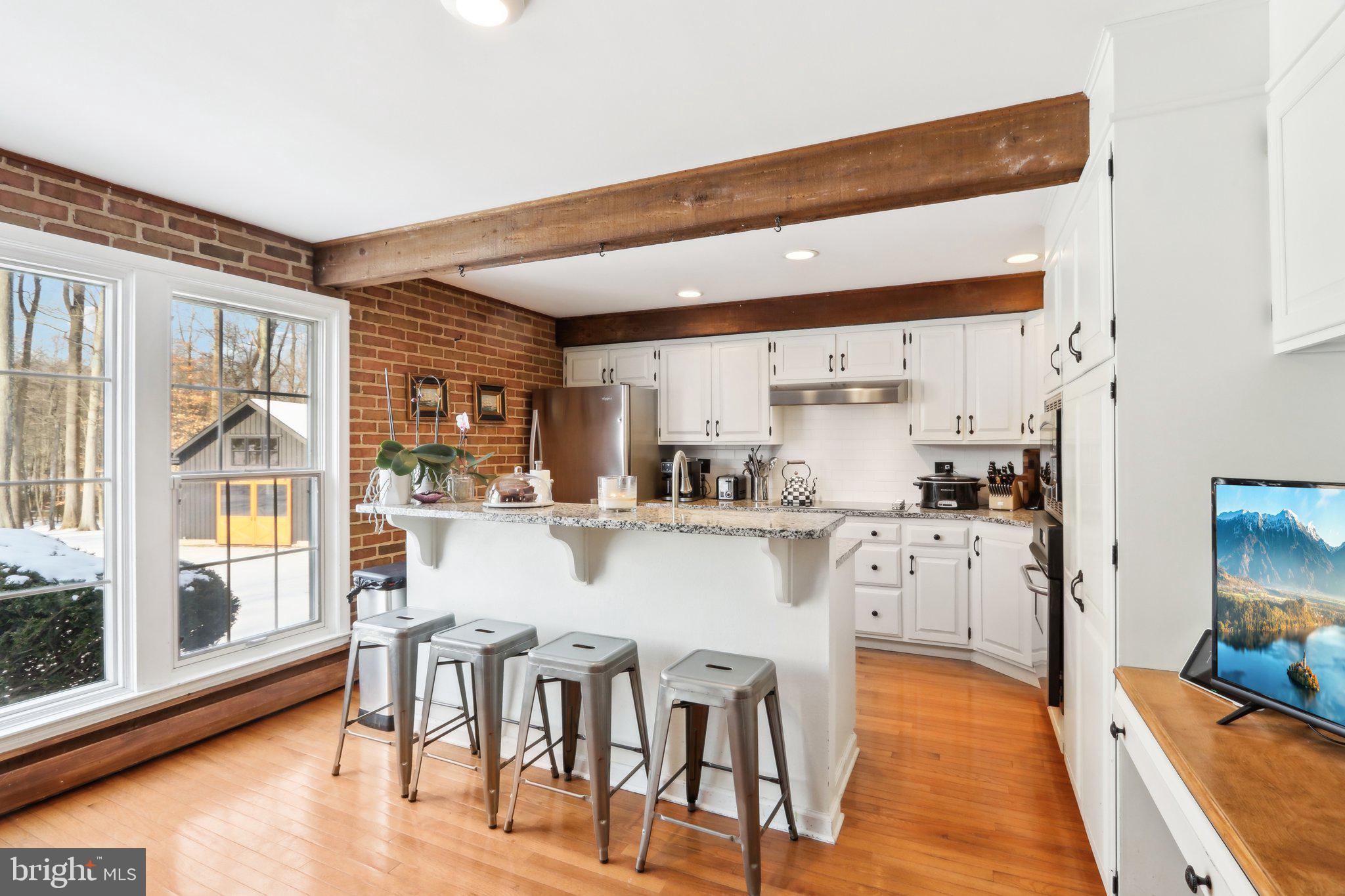 416 Dutton Mill Road Malvern, PA 19355 - Photo 12 of 56 a kitchen with stainless steel appliances granite countertop a stove top oven a dining table and chairs with wooden floor