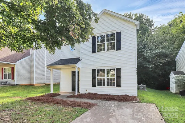 a front view of a house with a garden and yard