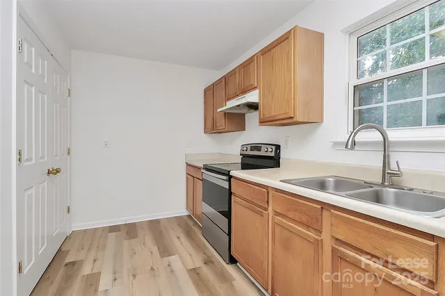 a kitchen with a sink cabinets and a wooden floor