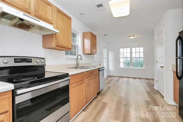a kitchen with kitchen island granite countertop a stove and a sink