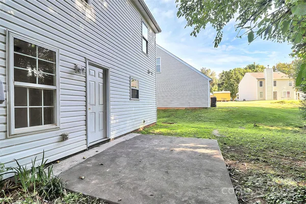 a view of a house with backyard and a trees